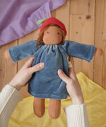 Nanchen Waldorf Doll Garden Child lene with apple hat in an adult's hand in the Babipur playroom. 