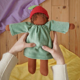 Nanchen Waldorf doll garden child Lilly with apple hat in an adult's hand in the Babipur playroom.