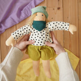 Nanchen Waldorf doll Mascha in an adult's hand in the Babipur playroom.
