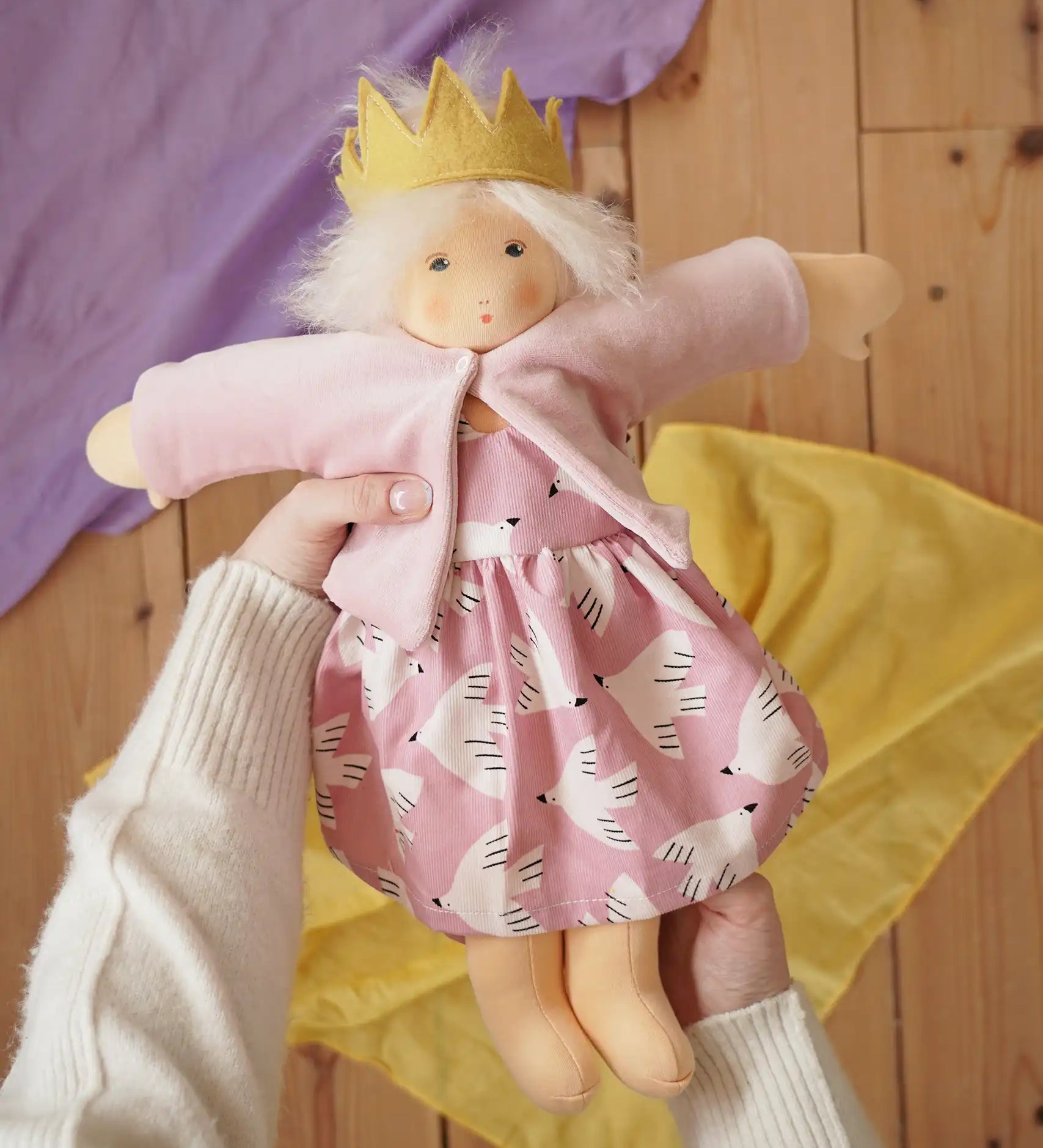 Nanchen Waldorf doll Rosi in an adult's hands in the Babipur playroom. 