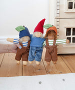 Three Nanchen Waldorf dolls lined up. Bela blueberry, Frederik and  Otto Orange. The dolls all have removable outfits and hats. The Plan Toys Victorian dolls house can be seen in the background. 