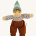 Nanchen Forest Child Waldorf Doll - Sage. This beautifully handcrafted doll wears sage velour trousers, a brown hat and a floral top. On a cream background