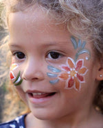 Close up of a woman's face decorated with colourful Natural Earth face paints