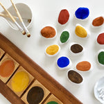 Close up of some pebbles painted in white and coloured Natural Earth eco-friendly paints