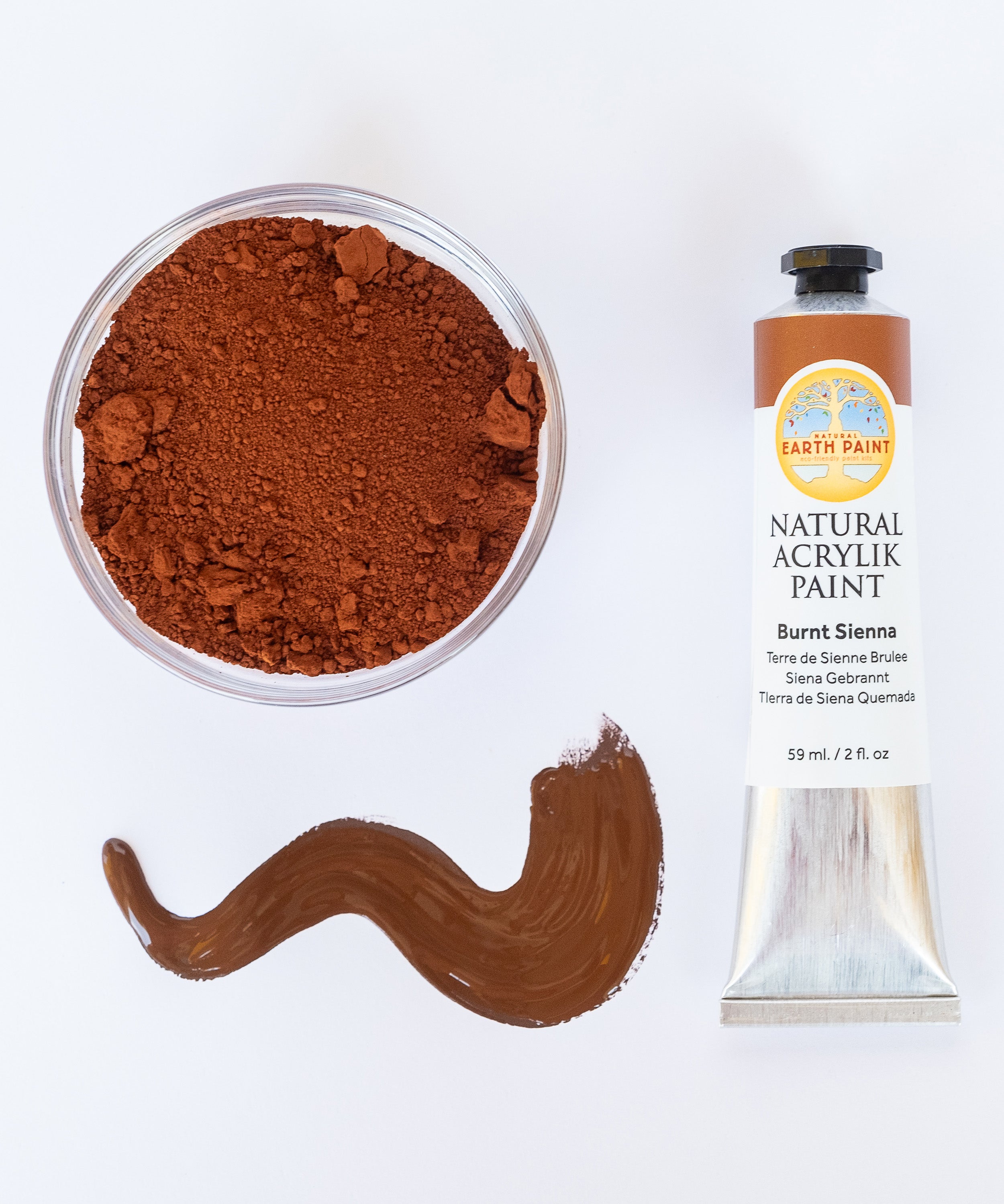 A top down view of the Natural earth paint tube in burn sienna next to a bowl of matching pigment and a paint streak showing the consistency. 