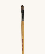 A close up view of the size 12 Natural Earth paint brush showing the wooden handle and brand name printed on the side