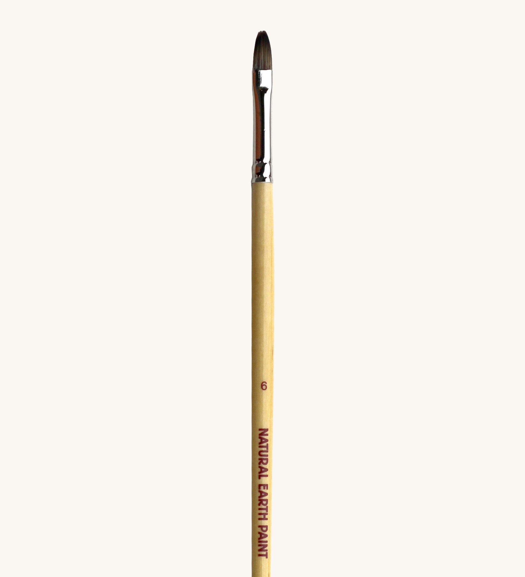 A close up view of the size 6 Natural Earth paint brush showing the wooden handle and brand name printed on the side