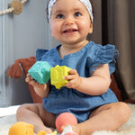 A child happily playing with the Sophie The Giraffe - So Pure Early Learning Gift Set