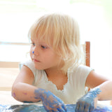 A close up of a child mixing different coloured Neogrun finger paints and making crafts