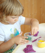 A child getting crafty and playing with the purple organic Neogrun play dough.