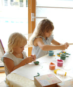2 kids sitting by a table and being crafty with the Neogrun organic play dough