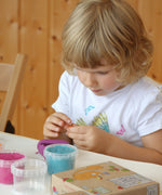 A close up of a child being creative with the purple and blue Neogrun organic play dough