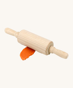 Neogrun wooden rolling pin on top of the orange organic play dough. Features handles on each side for easy handling