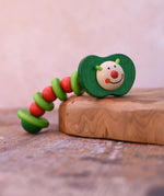 Nic apple worm baby wooden grasping toy. Smiling worm on a flexible rope lined with chunky red and green beads.