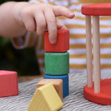 Child stacking blocks from the Nic BIO red rolling shape sorter wooden toy.