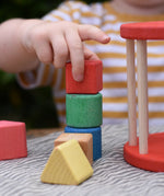 Child stacking blocks from the Nic BIO red rolling shape sorter wooden toy.