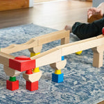 Nic Cubio wooden Ball Track Extension Set shown set up, a child has just placed a red ball on the track. Wooden balls are available to purchase separately. 