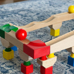 Nic Cubio wooden Ball Track Extension Set shown set up with a red  and yellow ball shown on motion on the track. Wooden balls are available to purchase separately. 
