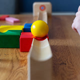 The Nic Cubio Wooden Marble Run Starter Set up with the outlet with bell end piece placed at the end. A yellow coloured can be seen on the track. 