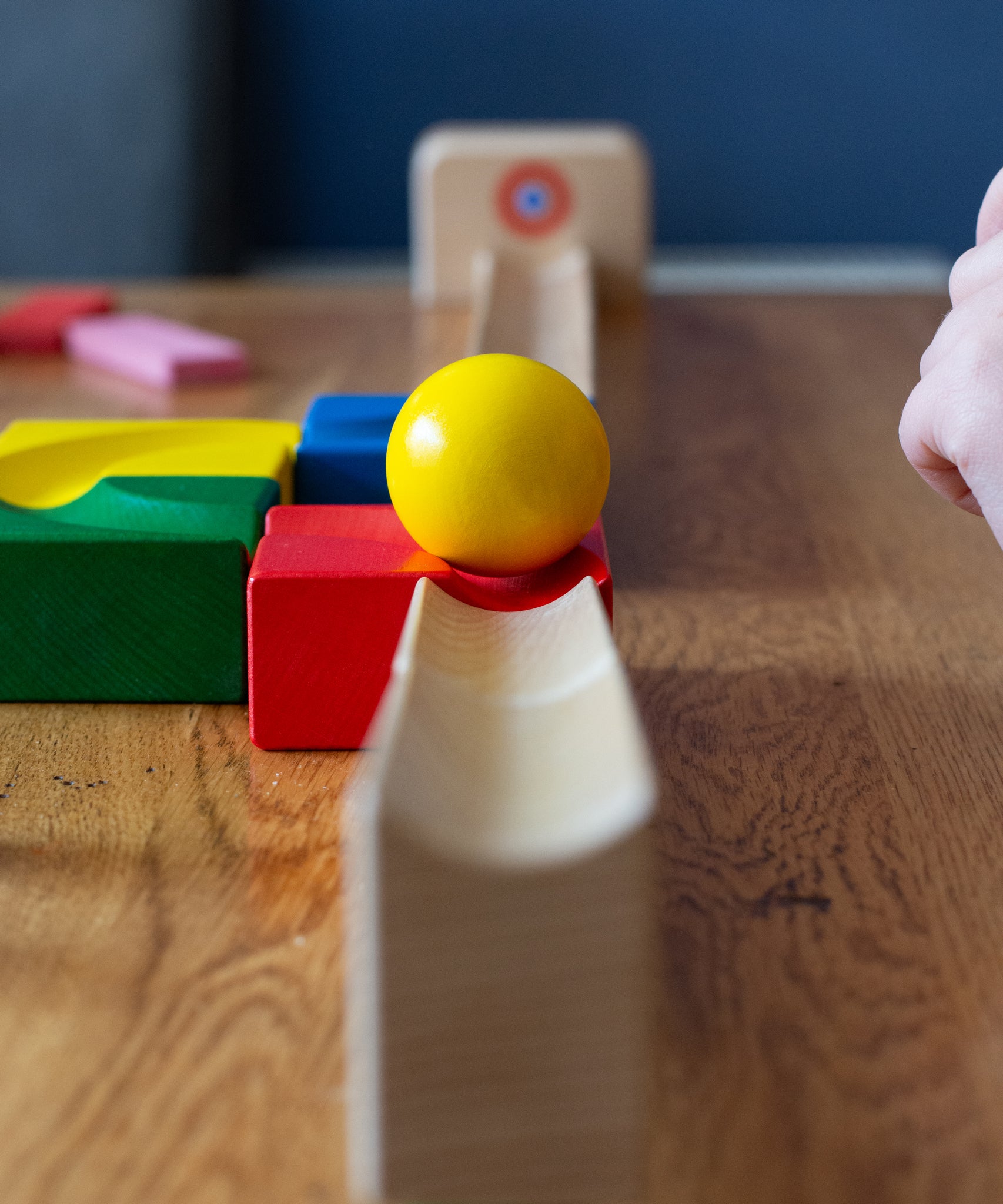 The Nic Cubio Wooden Marble Run Starter Set up with the outlet with bell end piece placed at the end. A yellow coloured can be seen on the track. 