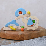 Nic dolphin, elephant and snail wooden baby toys stacked on top of each other.