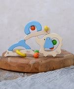 Nic dolphin, elephant and snail wooden baby toys stacked on top of each other.