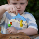 Nic dolphin wooden baby grasping toy in a child's hand.