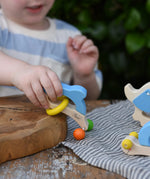 Child playing with the Nic dolphin wooden baby grasping toy.