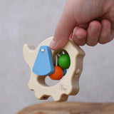 Back of the Nic elephant grasper wooden baby toy in a child's hand.