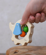 Back of the Nic elephant grasper wooden baby toy in a child's hand.