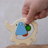 Nic elephant grasper wooden baby toy in a child's hand.