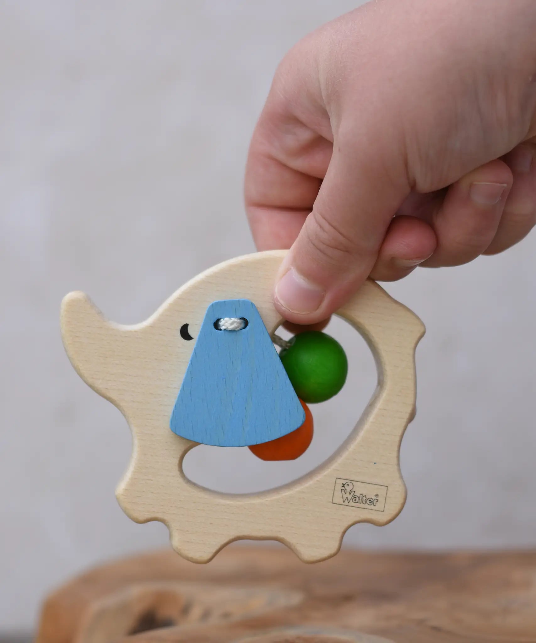 Nic elephant grasper wooden baby toy in a child's hand.