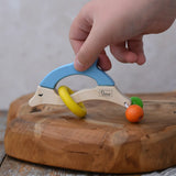 Child's hand reaching for the Nic dolphin wooden baby grasping toy.