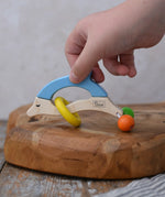 Child's hand reaching for the Nic dolphin wooden baby grasping toy.