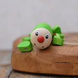Close up of the face on the Nic Willy the centipede green wooden baby toy.