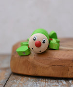 Close up of the face on the Nic Willy the centipede green wooden baby toy.