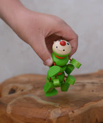 Nic Willy the centipede green wooden baby toy in a child's hand.