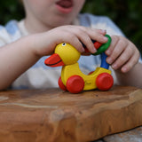 Child playing with the Nic Toys wooden yellow grip duck baby toy.