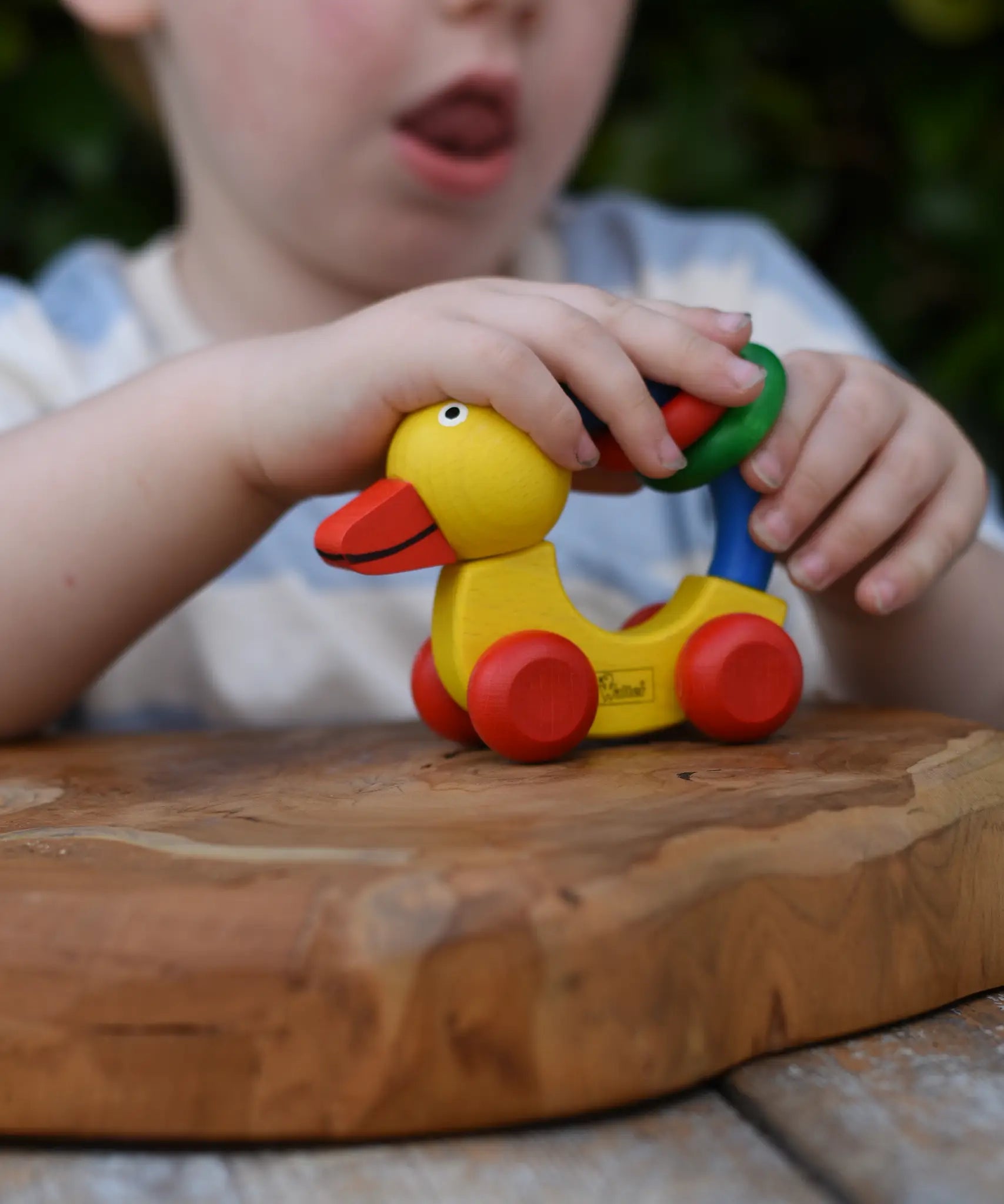 Child playing with the Nic Toys wooden yellow grip duck baby toy.