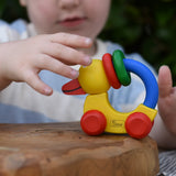 Child reaching for the Nic Toys wooden yellow grip duck baby toy.