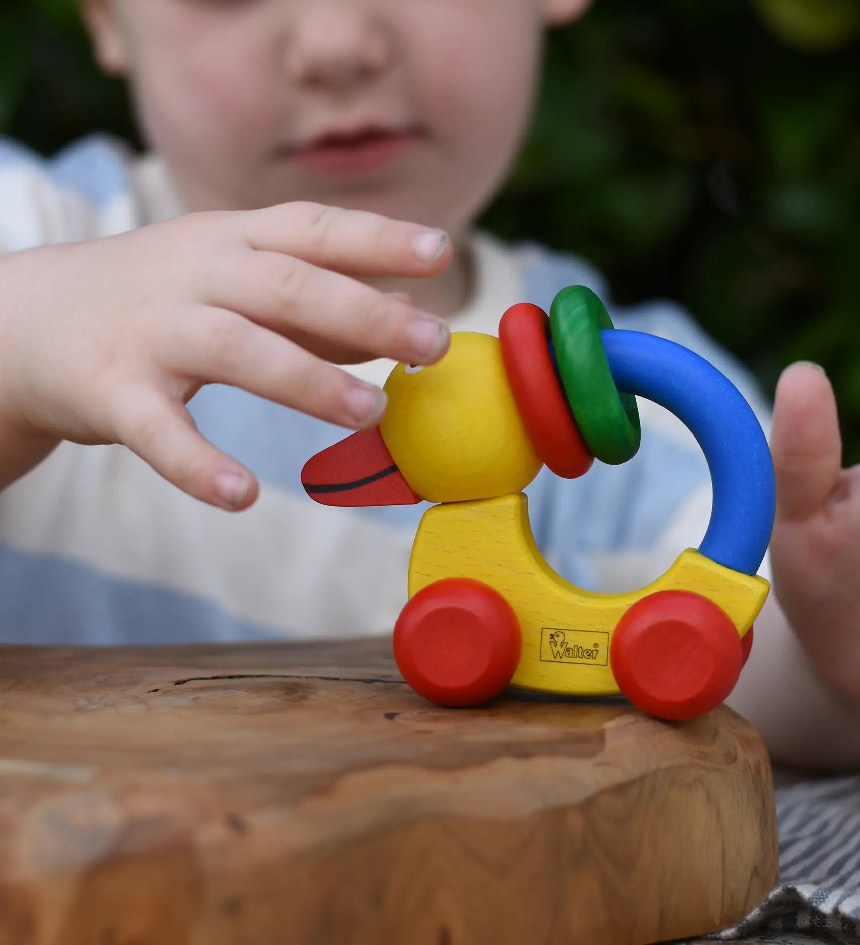 Child reaching for the Nic Toys wooden yellow grip duck baby toy.