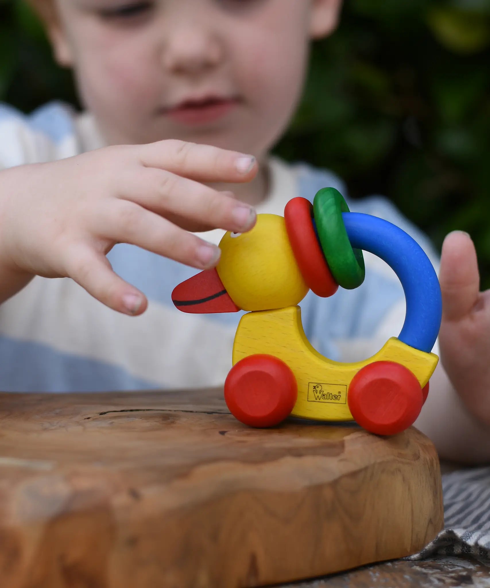 Child reaching for the Nic Toys wooden yellow grip duck baby toy.