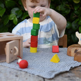 Child stacking the blocks from the Nic lock a bloc wooden shape sorter toy on top of each other. 