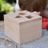 Top of the Nic lock a bloc wooden shape sorter toy box with three slots, triangle, square and circle.