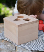 Top of the Nic lock a bloc wooden shape sorter toy box with three slots, triangle, square and circle.