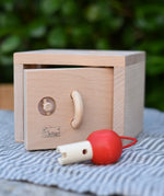 Front of the Nic lock a bloc wooden shape sorter toy with the door slightly ajar.
