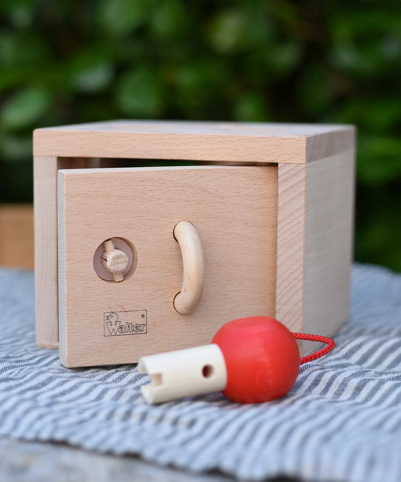 Front of the Nic lock a bloc wooden shape sorter toy with the door slightly ajar.