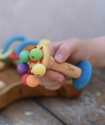 Nic organic carousel rattle spinning baby grasping toy in a child's hands.
