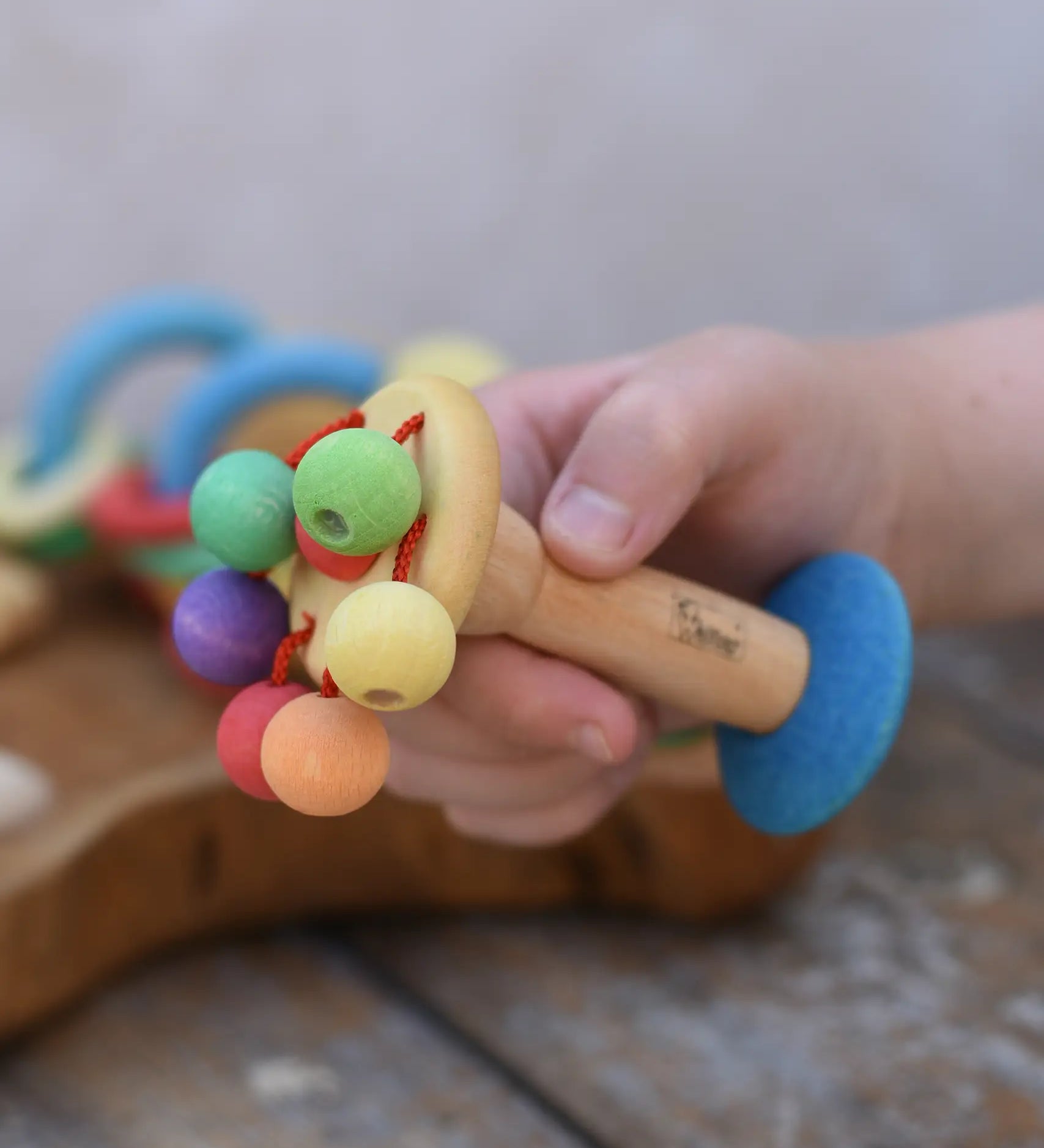 Nic organic carousel rattle spinning baby grasping toy in a child's hands.