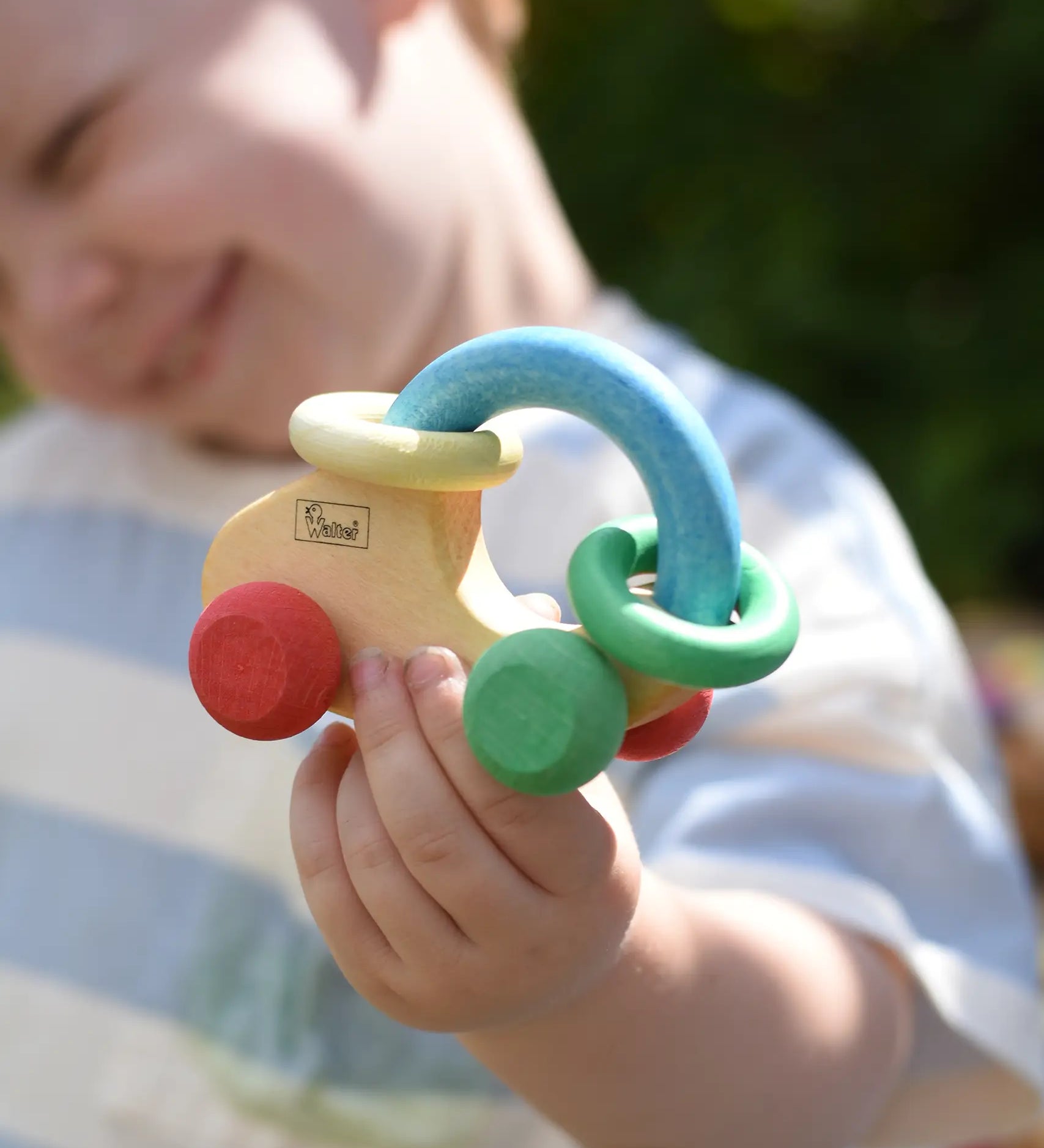 Nic organic grip car wooden baby toy in a child's hand.